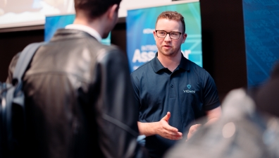 Male viden employee speaks to interested career transitioner at event
